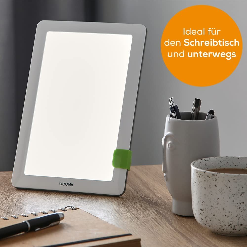 Daglichtlamp op tafel. Tekst: Ideaal voor op het bureau en onderweg. Merk: beurer.
