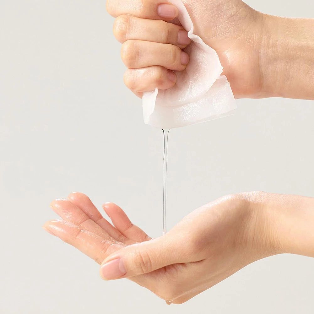 Des mains pressent un tissu, le sérum coule dans une paume.