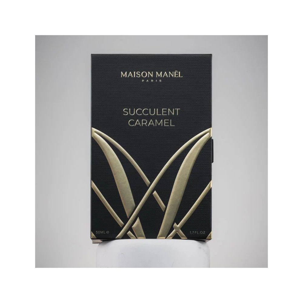Boîte noire avec logo et texte dorés. "Succulent Caramel" et "Maison Manel Paris" sont visibles.