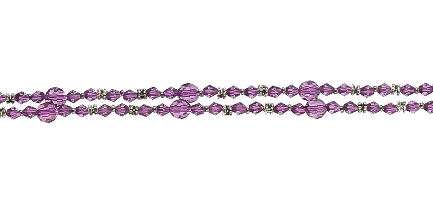 Close-up van een brillenketting met paarse kralen en zilverkleurige elementen. Twee strengen, horizontaal geplaatst.