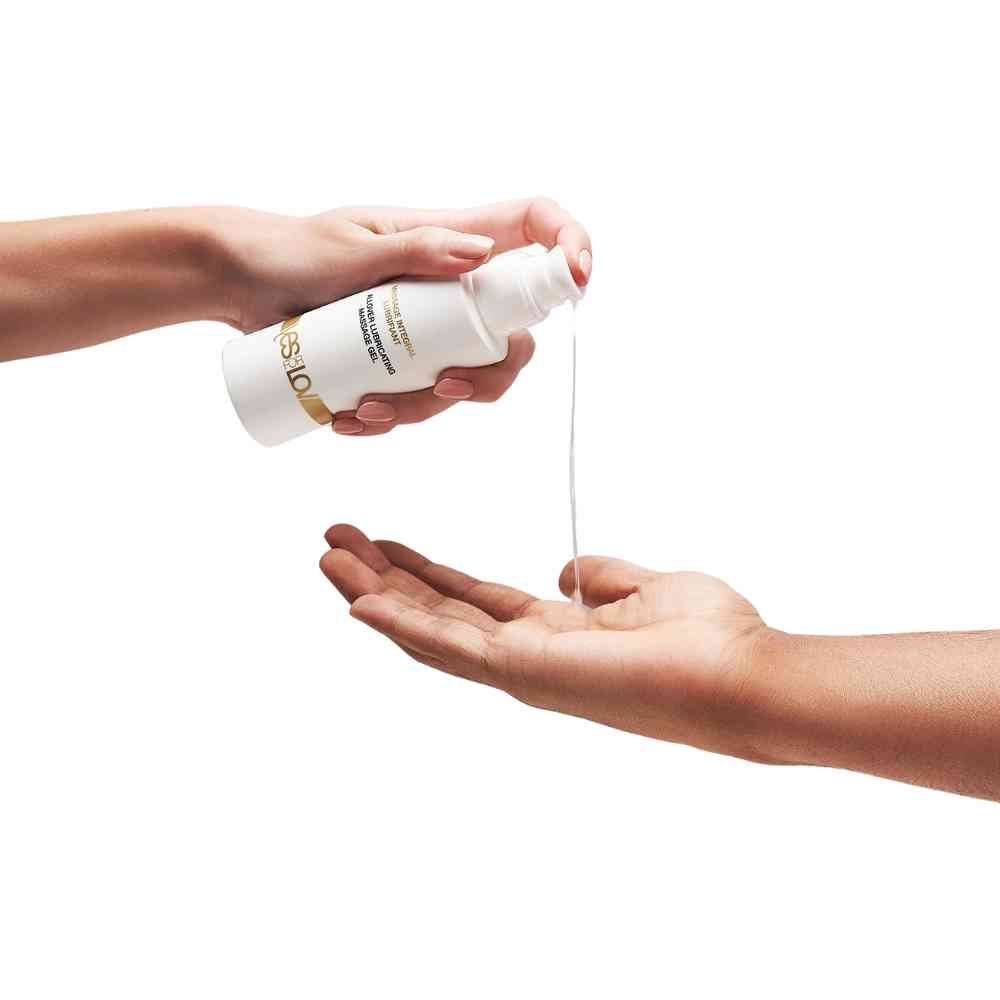Eén hand schenkt massagegel uit een fles in een andere hand.