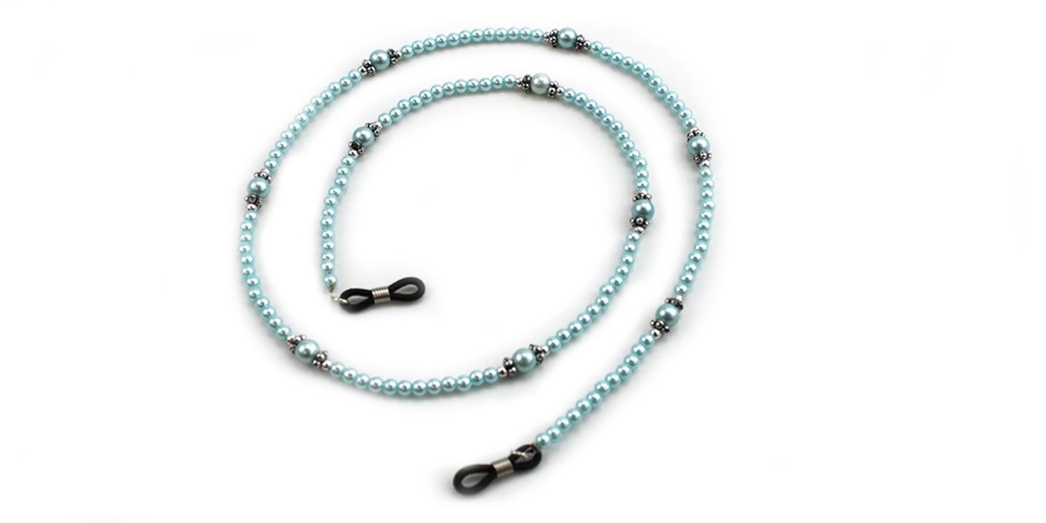 Cordon à lunettes avec perles bleu clair et éléments argentés. Extrémités avec boucles pour fixation aux branches.