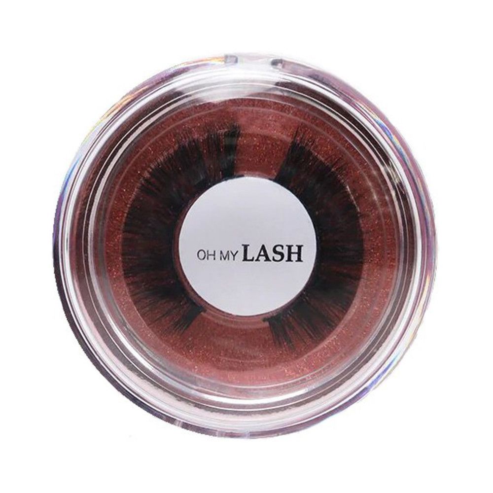 Faux cils dans un emballage rond transparent. Inscription : OH MY LASH. Fond marron.