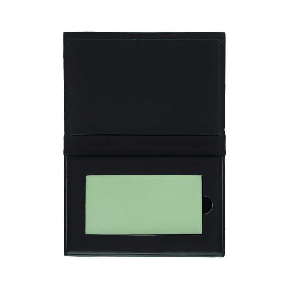 Correcteur vert dans un emballage noir ouvert. Produit rectangulaire dans une boîte avec une découpe.
