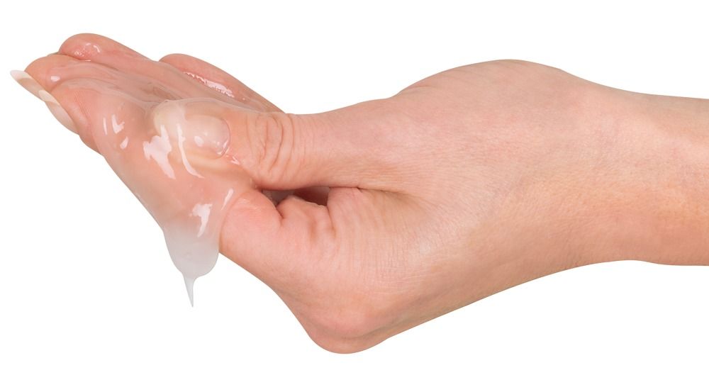 Paume avec du gel transparent tombant des doigts. Gel hybride à base d'eau et de silicone.