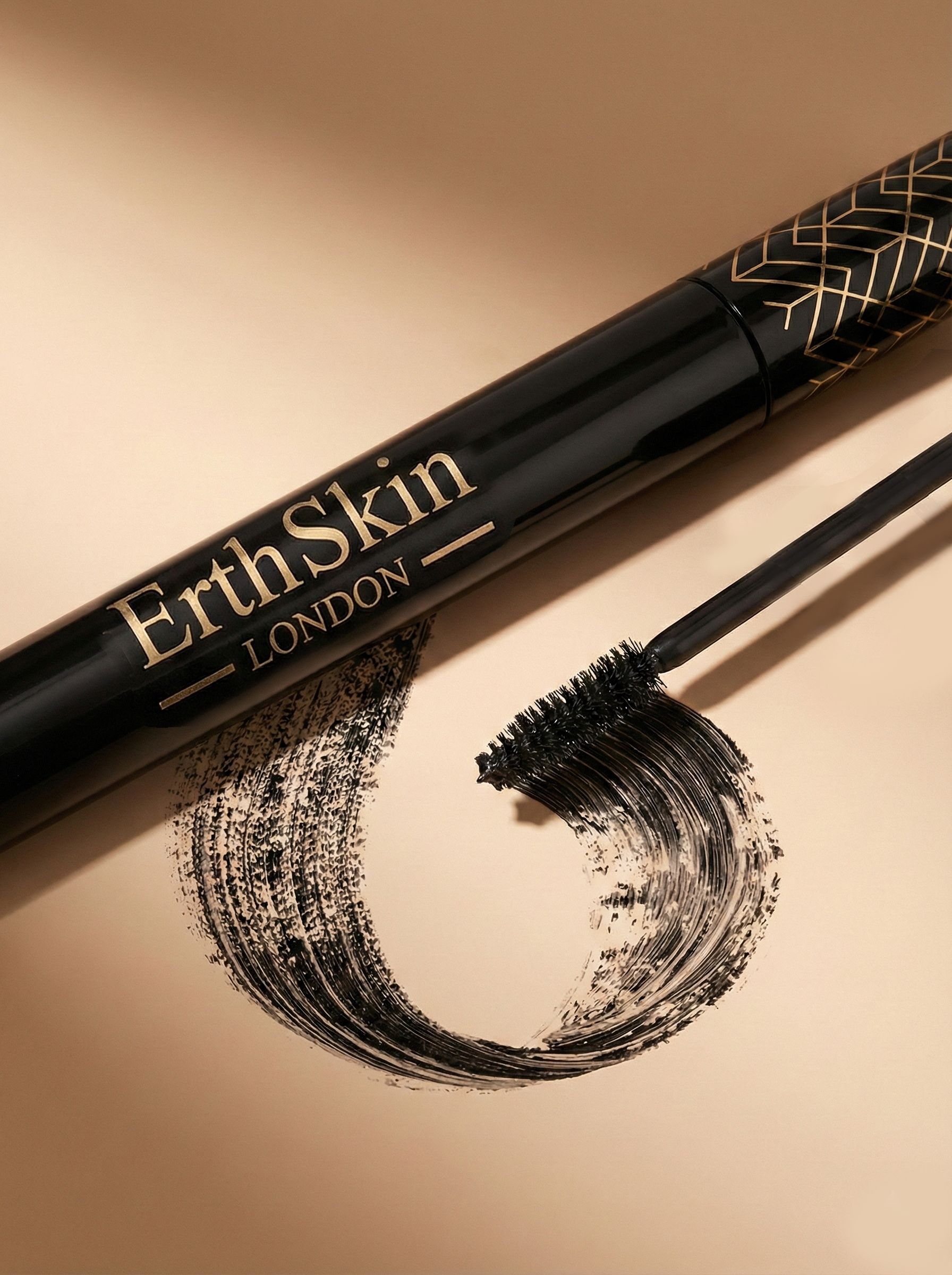 Zwarte mascara met gouden tekst 'ErthSkin LONDON' en aangebrachte borstel.