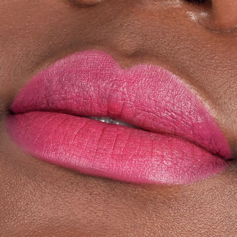 Gros plan sur des lèvres maquillées avec du rouge à lèvres rose. Les lèvres sont lisses et définies.