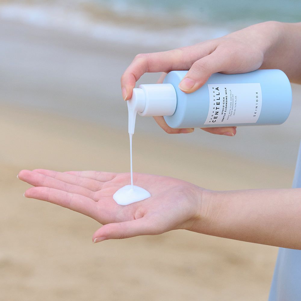 Een pompdispenser geeft reinigingsmelk af in een handpalm.
