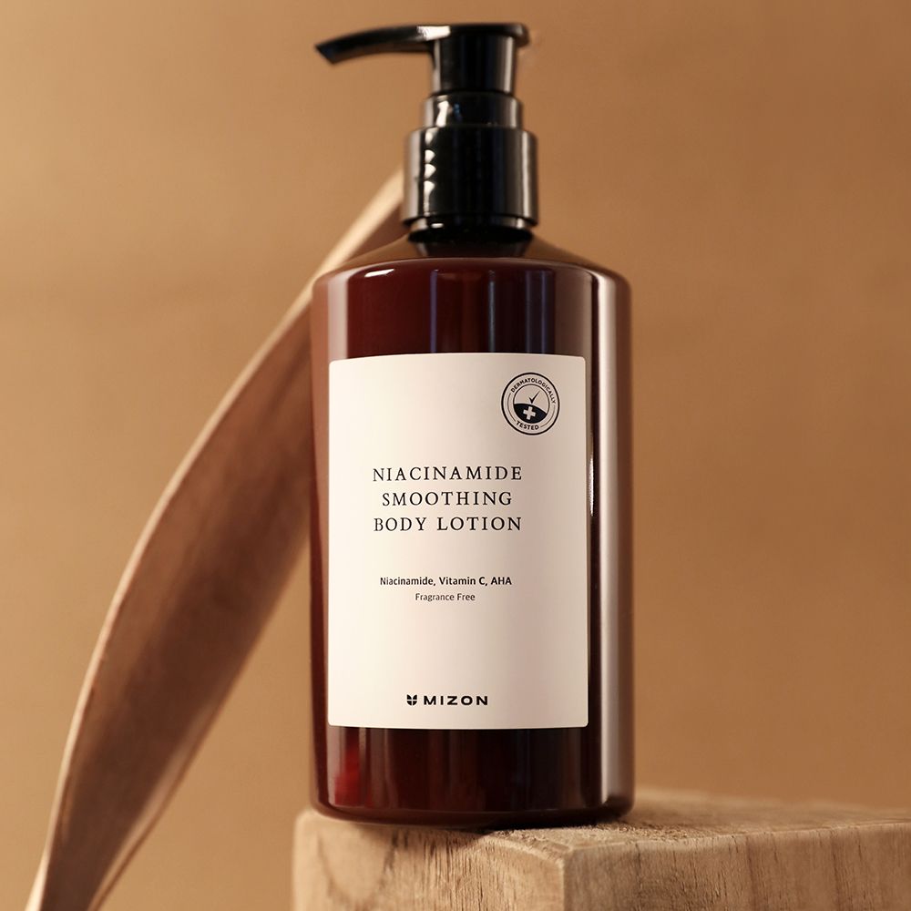 Bruine fles met zwarte pomp. Label met tekst: Niacinamide Smoothing Body Lotion. Merk: MIZON.