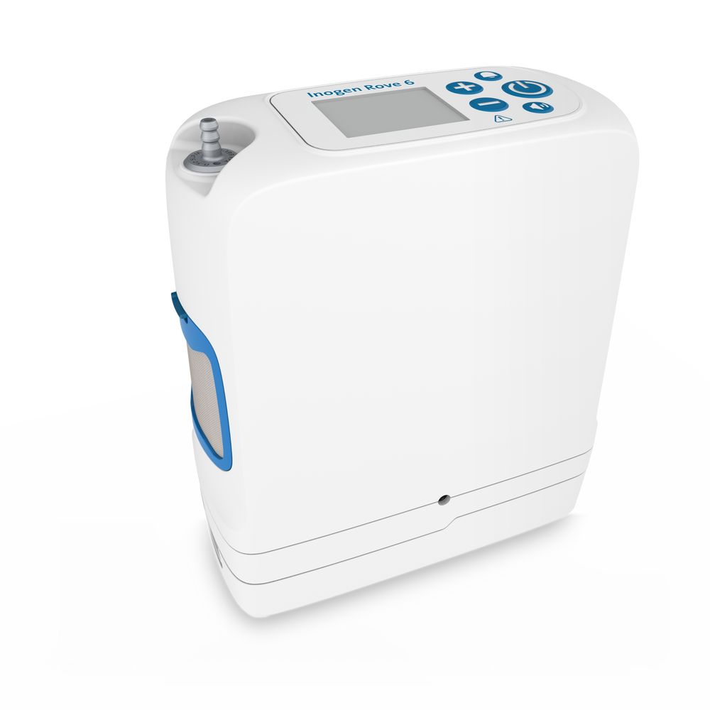 Mobiele zuurstofconcentrator. Witte behuizing met blauwe accenten. Bovenkant: display en knoppen. Opschrift: Inogen Rove 6.