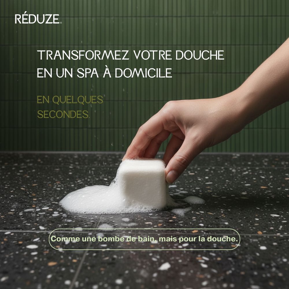 Main tenant un cube de douche blanc et moussant sur une surface noire.