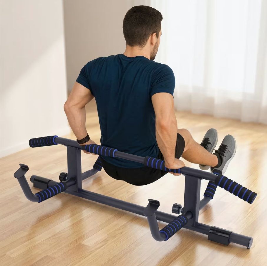 Homme s'entraînant sur une barre de traction. Structure métallique noire avec poignées bleues. Debout sur le sol.