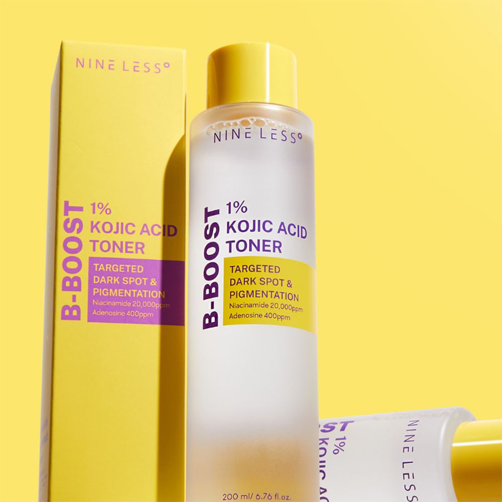 Flacon de toner et emballage. Inscription: NINE LESS, B-Boost, 1% Kojic Acid Toner. Fond jaune.