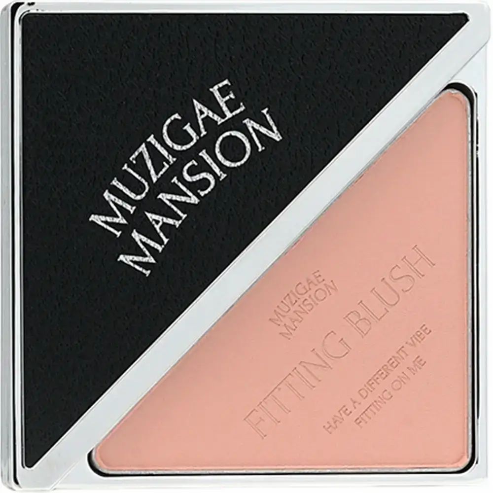 Blush in vierkante, zilverkleurige compactverpakking. Zwart deksel met MUZIGAE MANSION-logo. Roze blush met opschrift « FITTING BLUSH ».