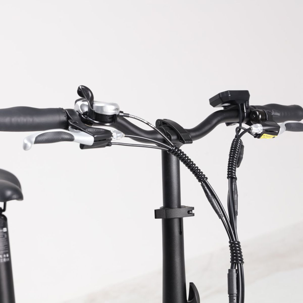 Stuur van de e-bike. Zwarte kleur, remhendels, bel en bedieningselementen. Kabels.