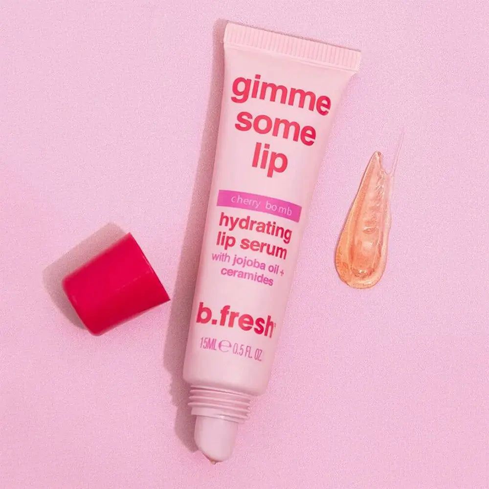 Roze tube met rode dop en serumdruppel. Opschrift: gimme some lip, Cherry bomb, hydrating lip serum, b.fresh.