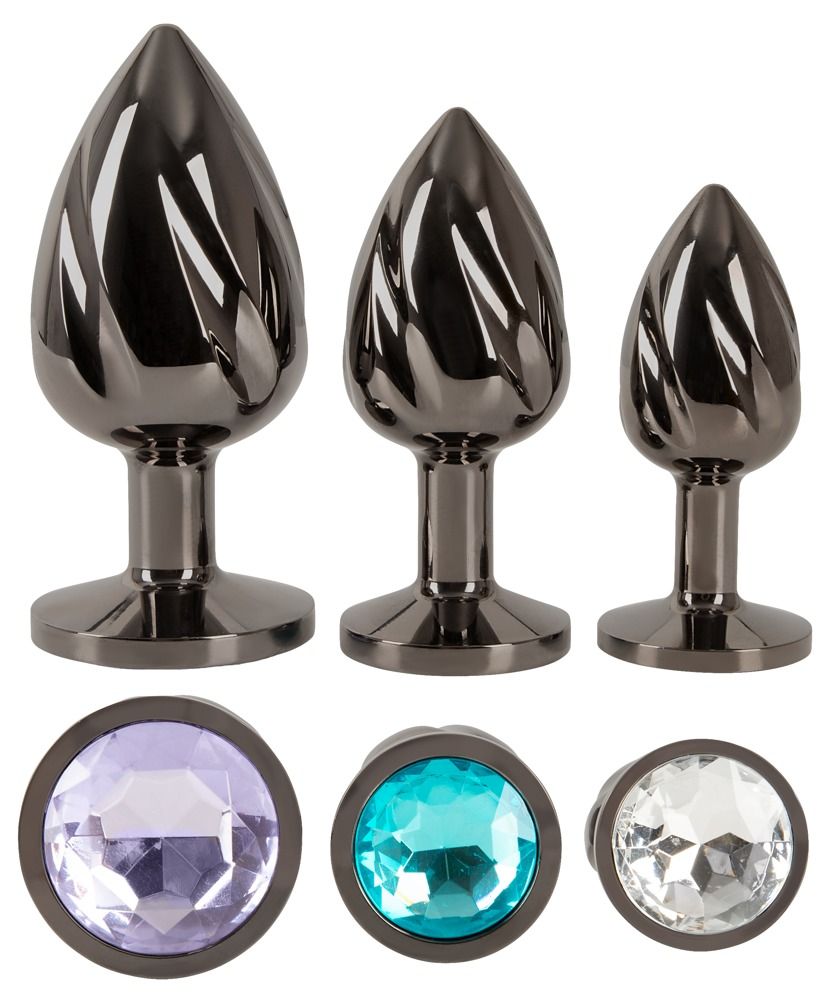 Trois plugs anaux en métal à surface torsadée avec des pierres précieuses rondes.