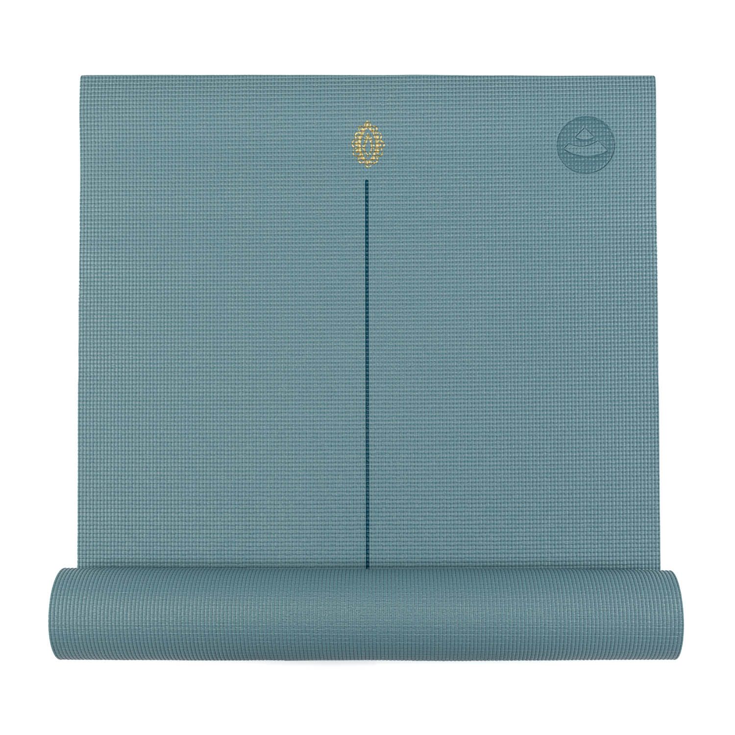 Tapis de yoga bleu-vert partiellement enroulé. Symbole de la main de Hamsa et logo. Surface en nid d'abeille. Une ligne centrale.