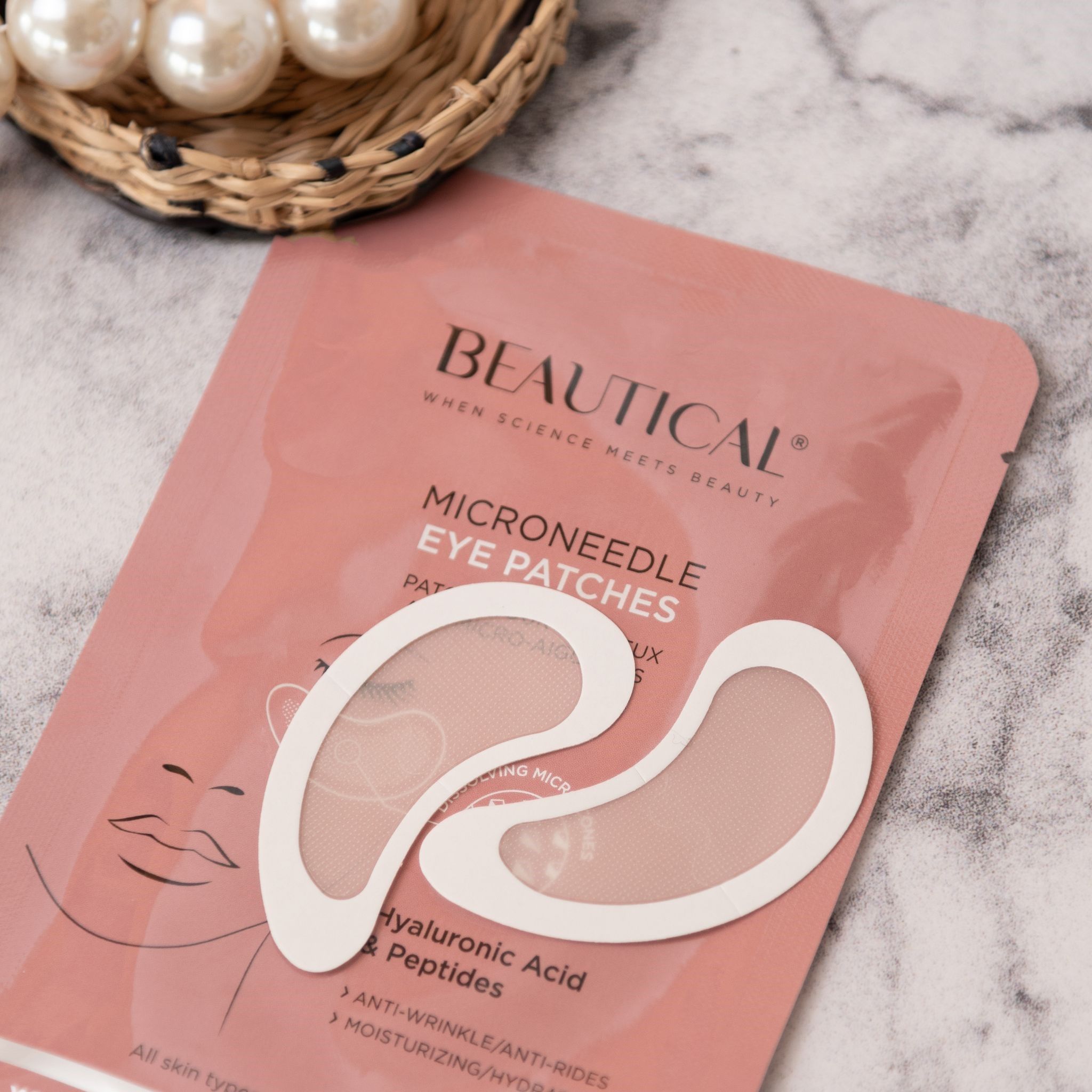 Emballage rose BEAUTICAL avec deux patchs pour les yeux et perles. Texte: Patchs pour les yeux, acide hyaluronique et peptides.