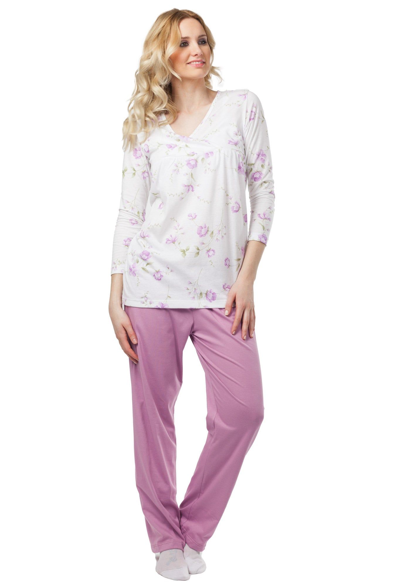 Ensemble de pyjama rose à motifs floraux. Haut à col en V et manches longues. Pantalon rose. Femme portant le pyjama.