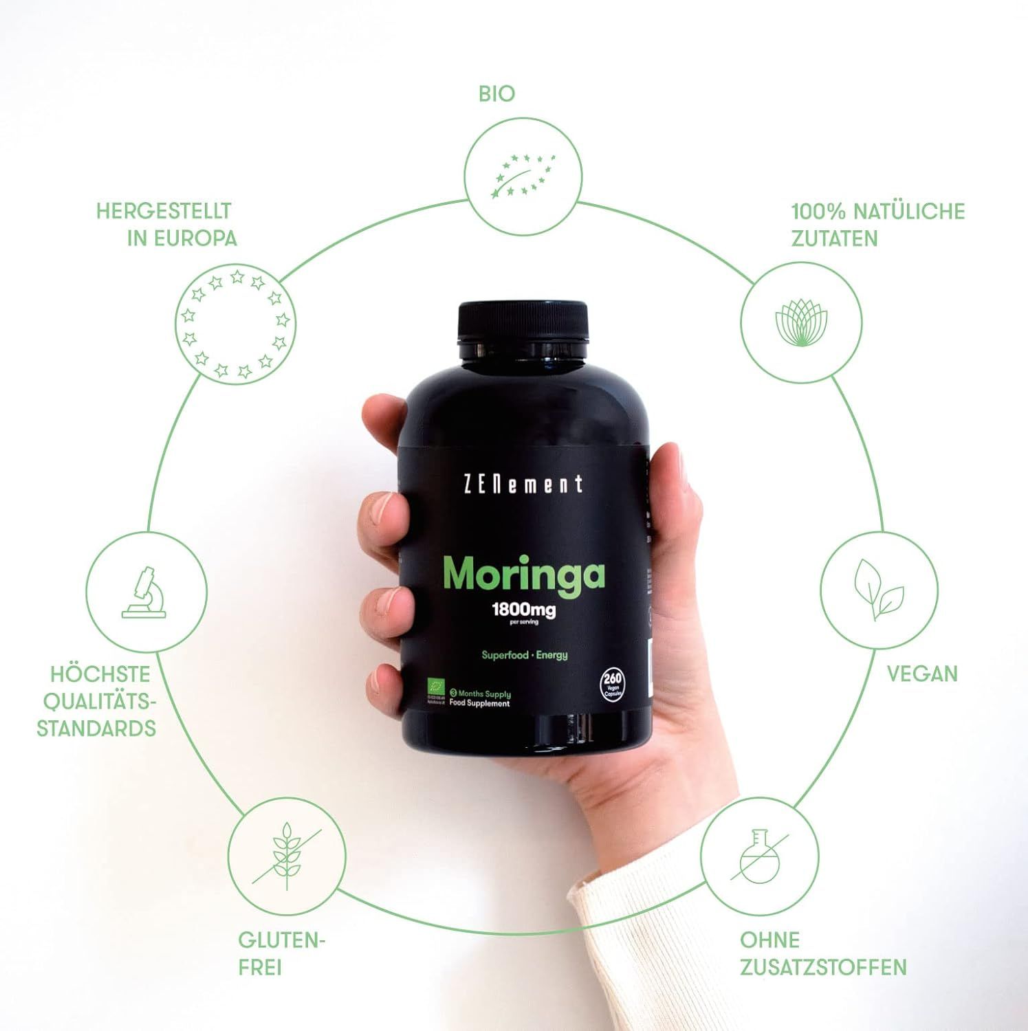 Zwarte fles Zenement Moringa capsules. Opschriften: 1800mg, bio, vegan, glutenvrij, zonder toevoegingen. Hand houdt de fles vast.