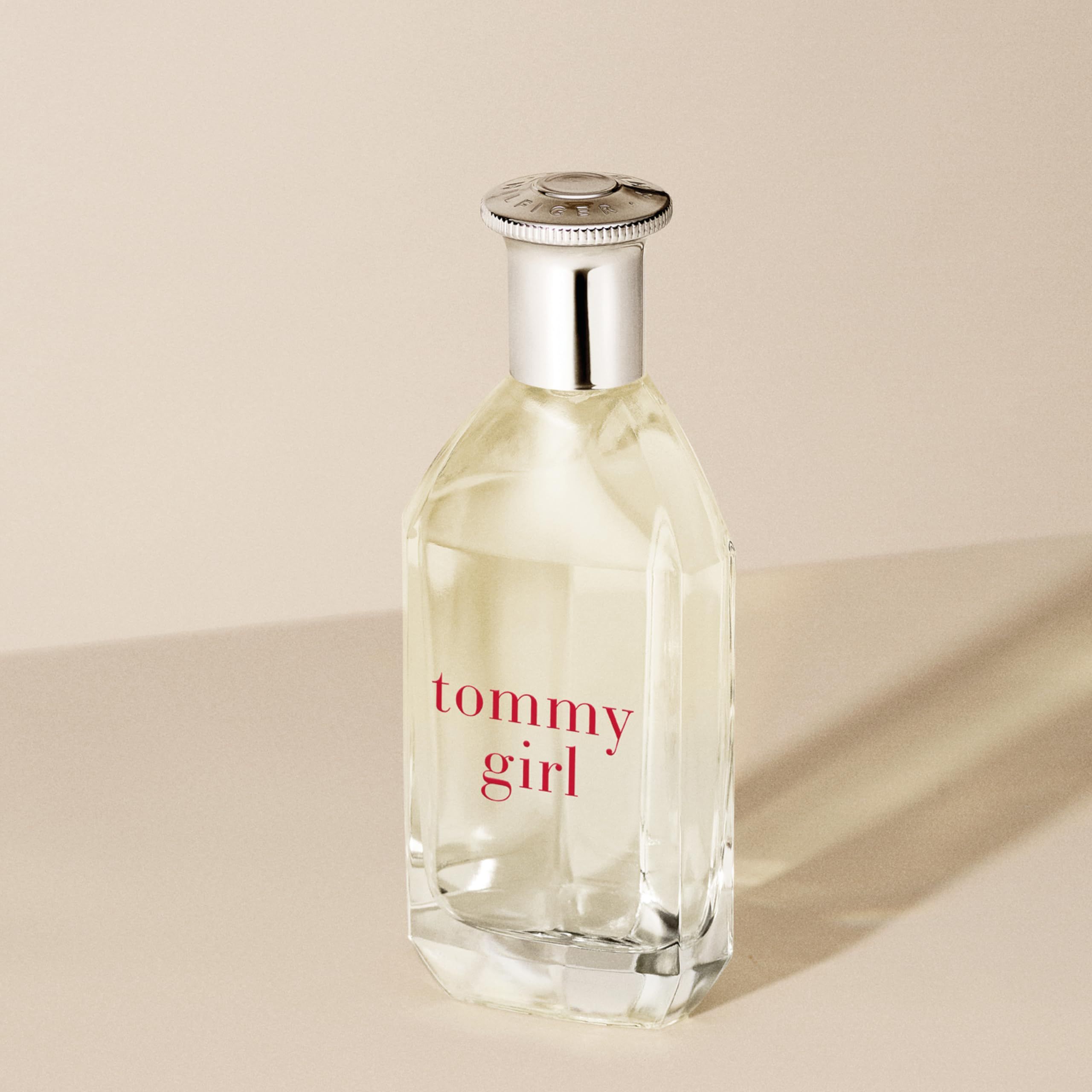 Glazen flesje met zilveren dop. "tommy girl" in roze. Op lichte achtergrond.