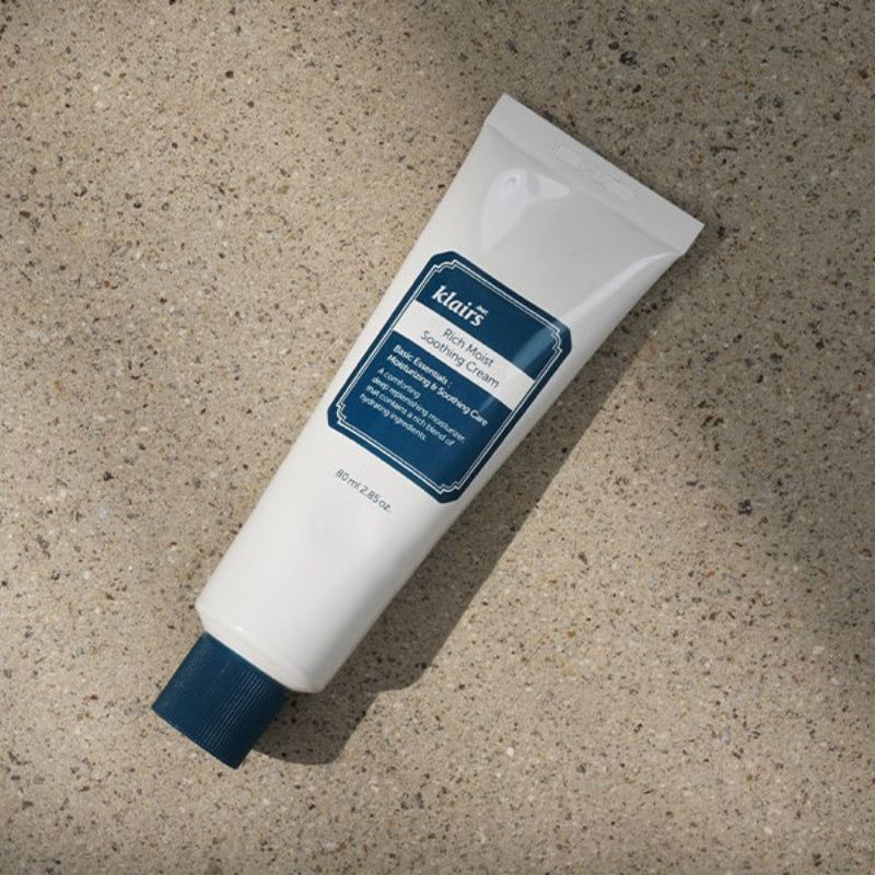 Witte tube met blauwe dop. Opschrift: klairs Rich Moist Soothing Cream. Op stenen ondergrond.