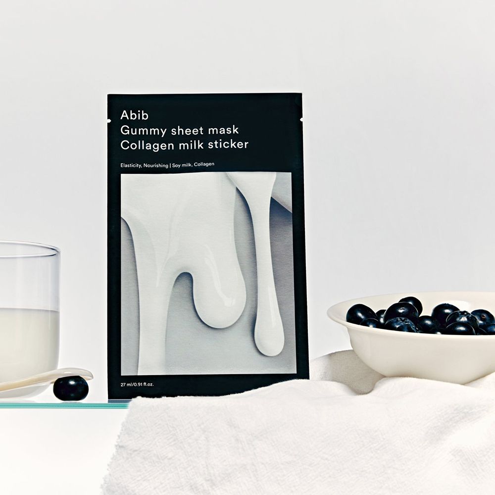 Productverpakking naast glas, kom met bosbessen en handdoek. Tekst: Abib Gummy Sheet Mask Collagen Milk Sticker.