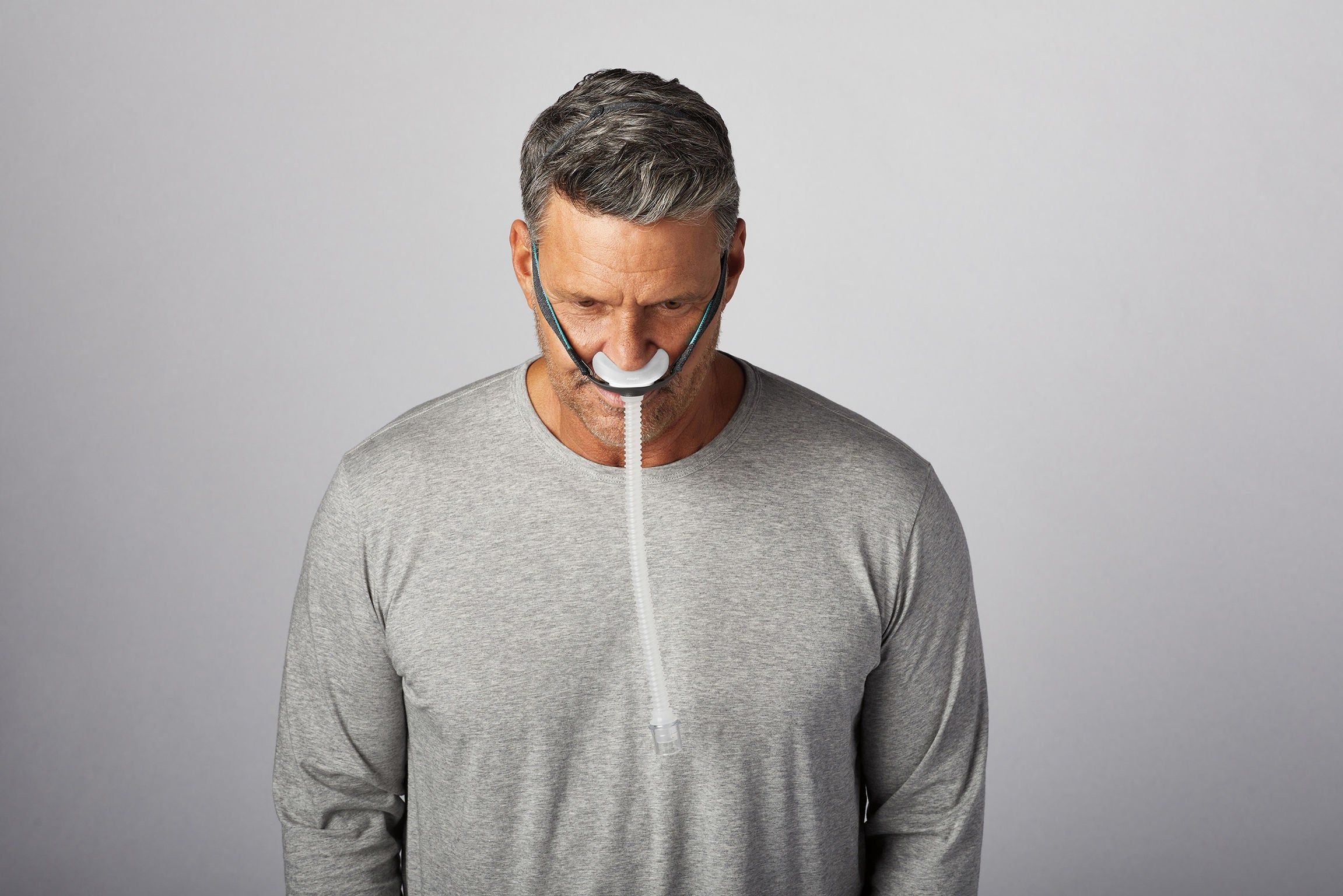 Man draagt CPAP-neusmasker met slang.