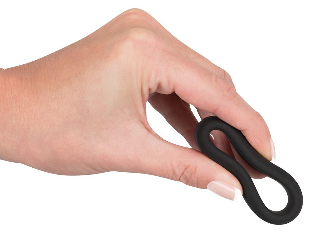 Anneau noir flexible en silicone tenu par une main.