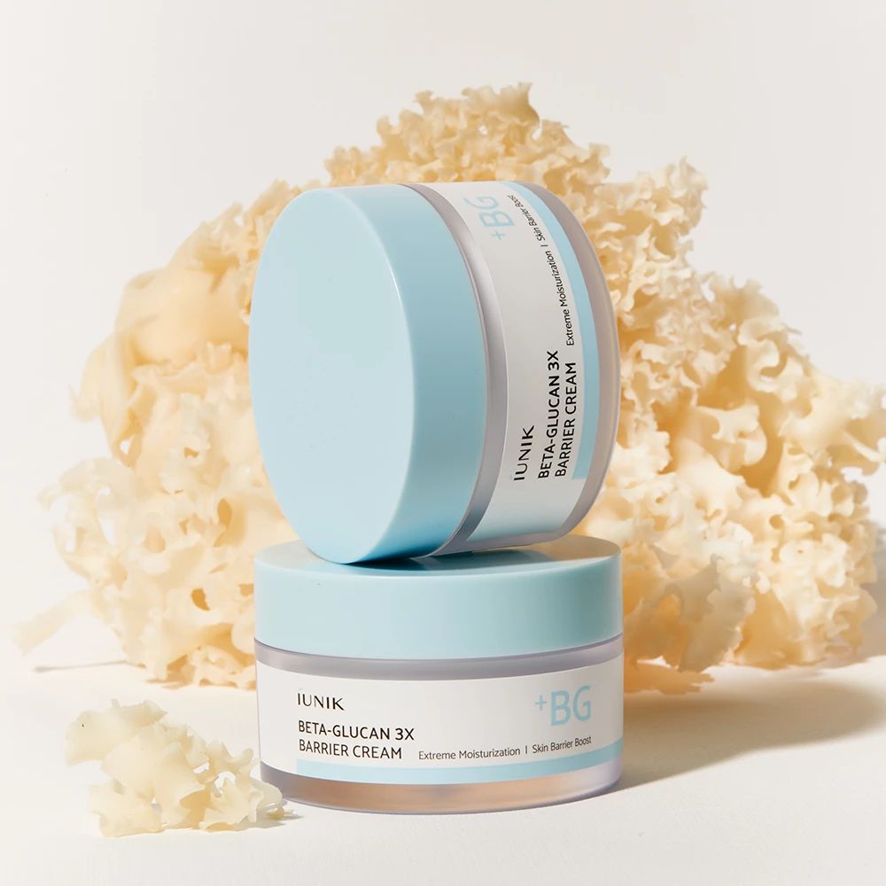 Deux pots de crème à couvercle bleu, superposés. Inscription : iUNIK, Beta-Glucan 3X Barrier Cream. Fond : champignon.