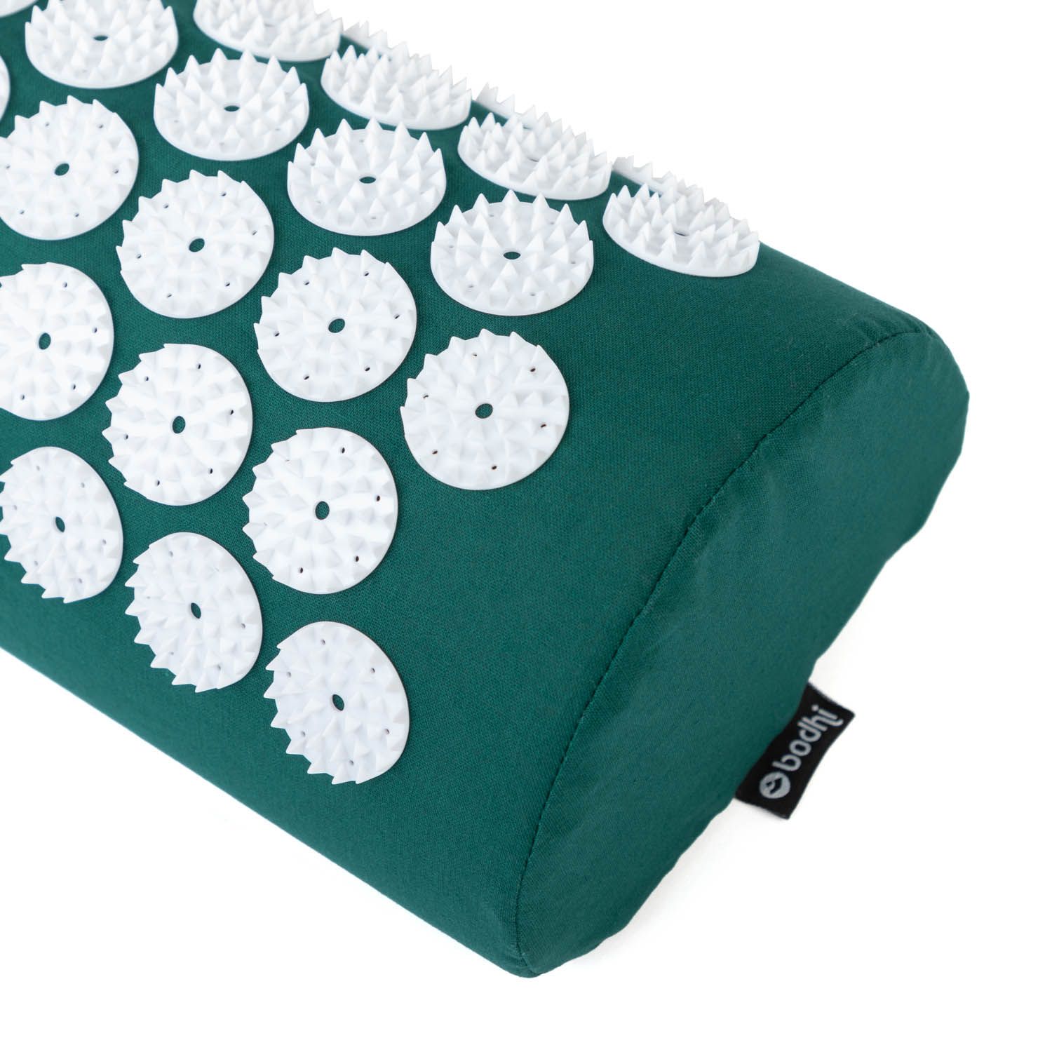 Close-up van het groene nekkussen met witte noppen. Zwart label met bodhi logo.