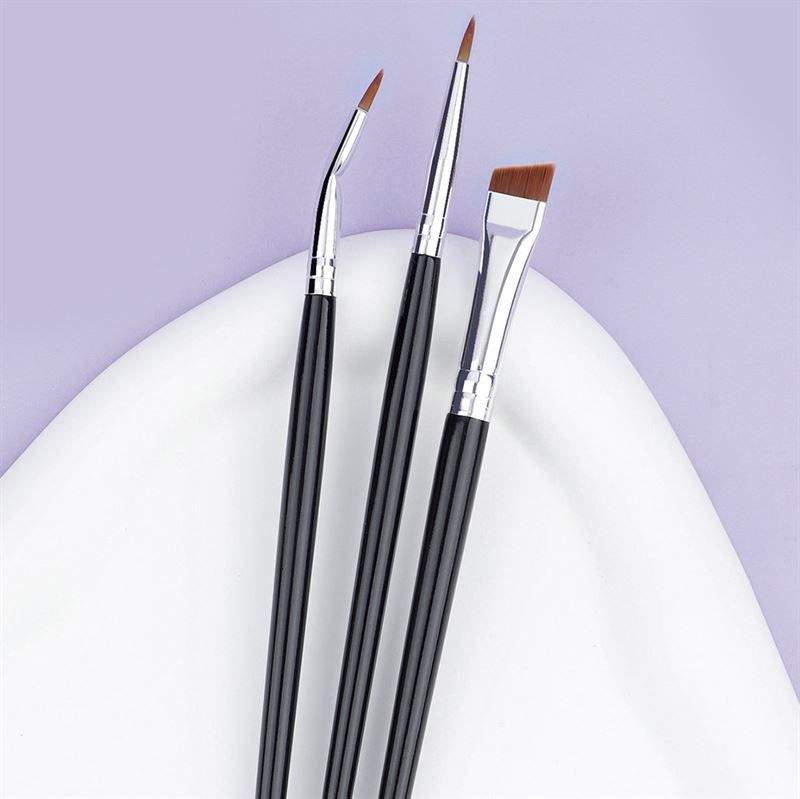 Drie oogmake-up kwasten met zwarte handvatten en zilveren hulzen op een witte ondergrond.