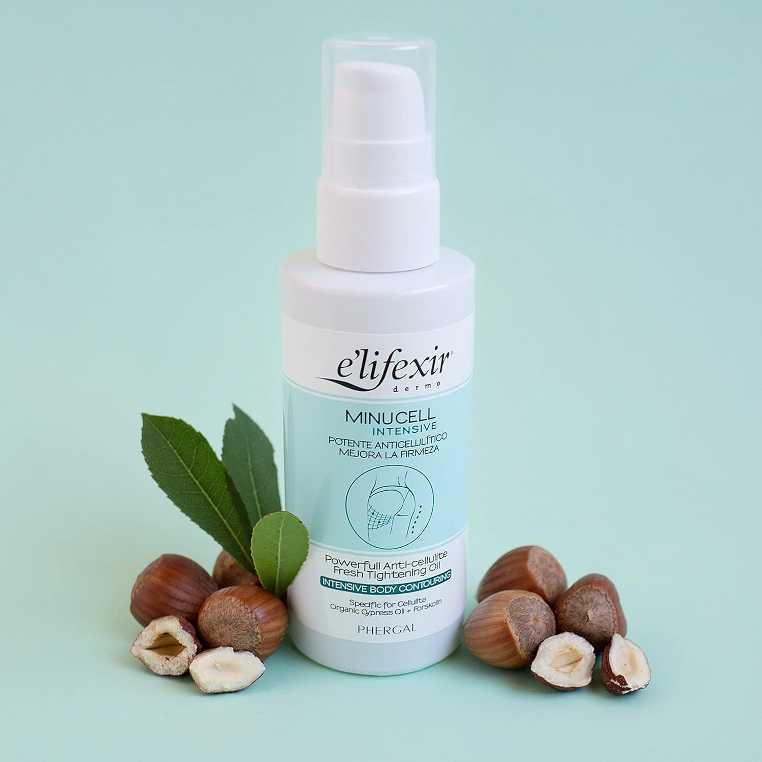 Flacon Elifexir Minucell Anti-Cellulite-Öl avec noisettes et feuilles. Fond turquoise.