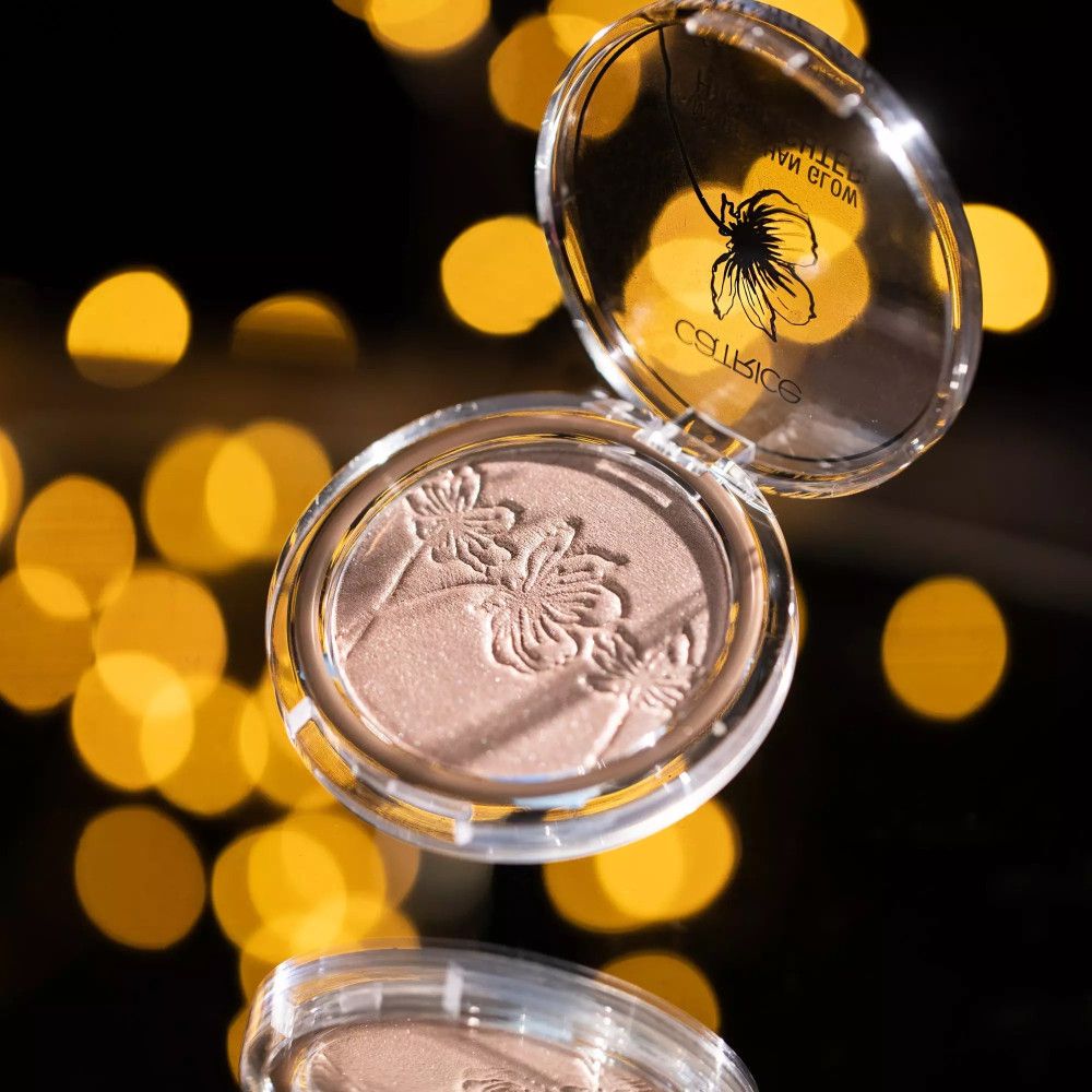 Highlighter Catrice dans un emballage transparent, ouvert. Sur fond noir avec effet bokeh.