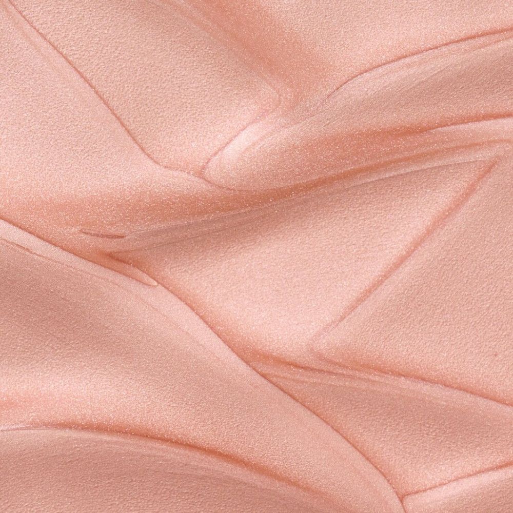 Gros plan d'un liquide rose brillant. La surface est texturée et rappelle un motif plié.