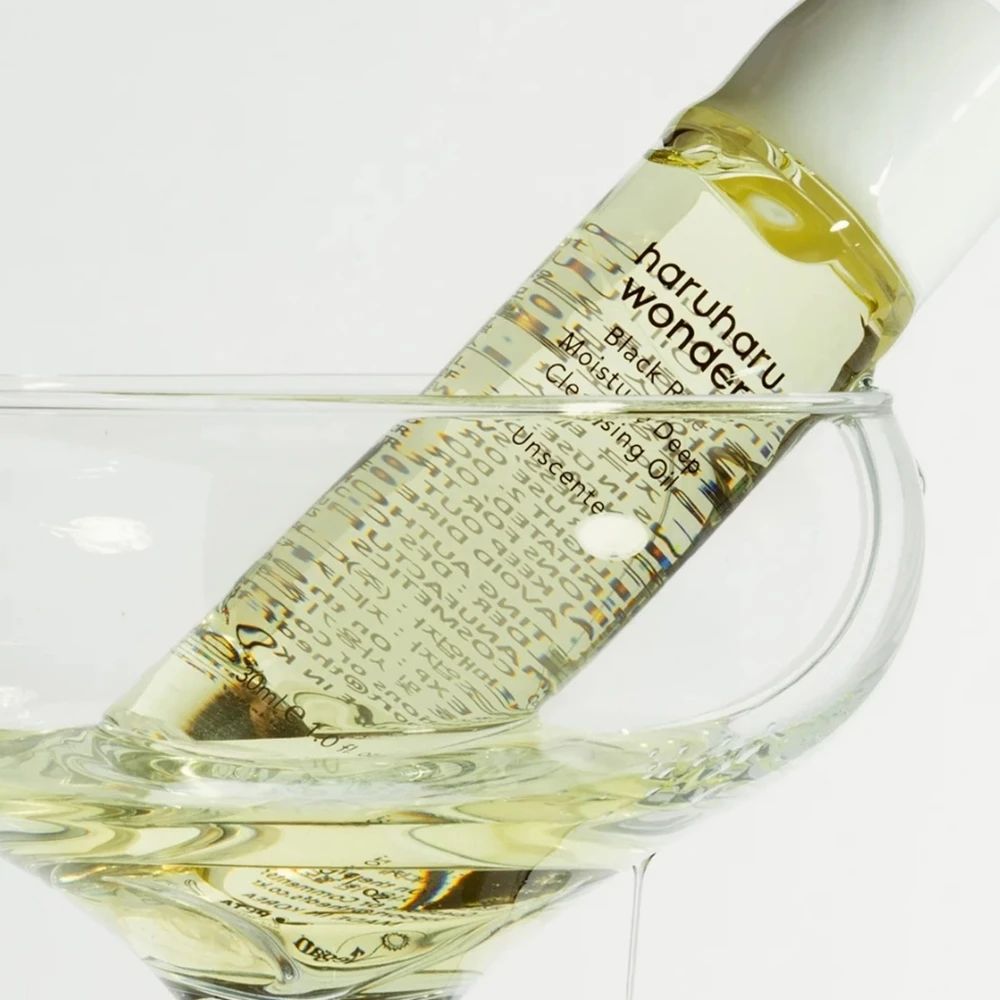 Flacon d'huile nettoyante dans un verre. Inscription : haruharu wonder Black Rice Moisture Cleansing Oil.