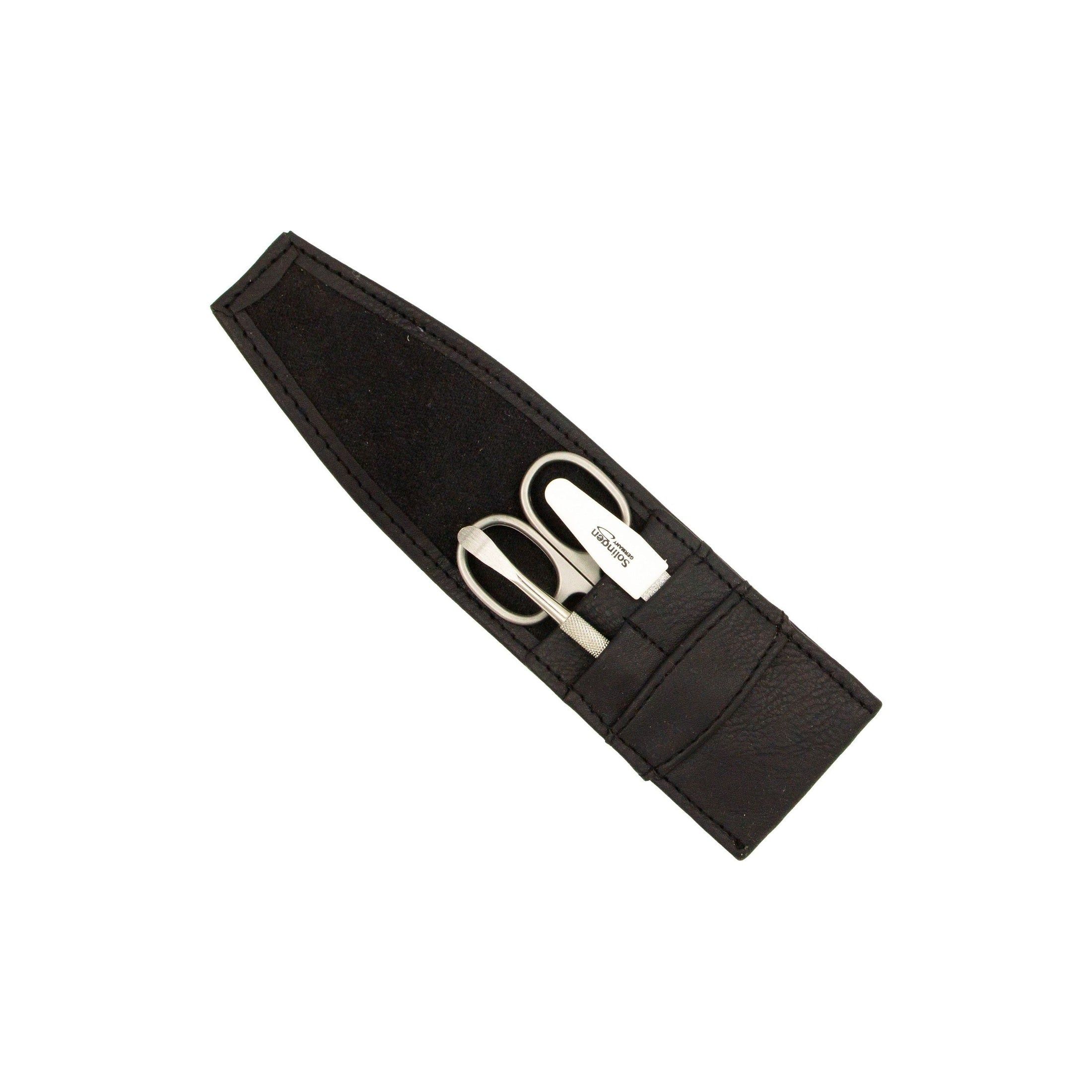 Étui en similicuir noir avec ciseaux à ongles et lime. Contenu visible.