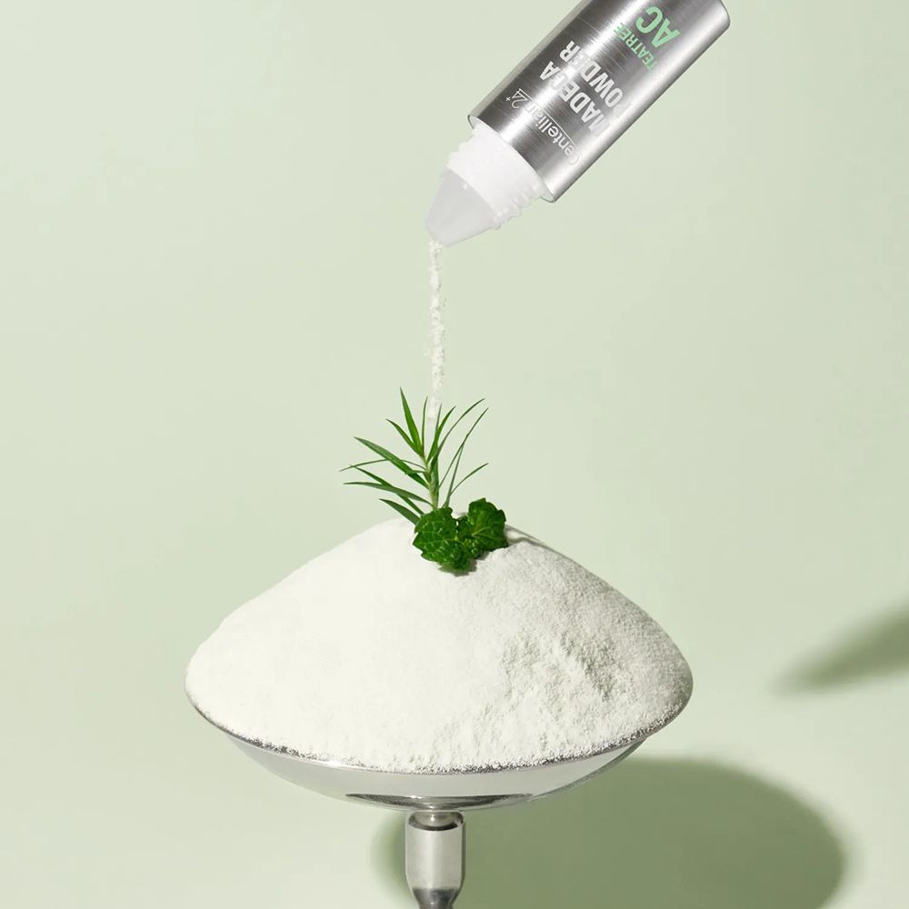 Centellian24 Madeca Powder TeaTree AC fles bovenop een hoop poeder.