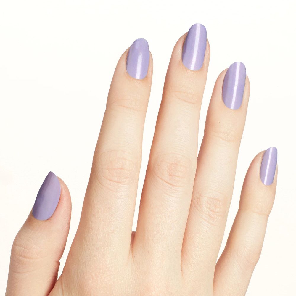 Main avec ongles vernis lilas clair. Les ongles sont ovales et brillants.