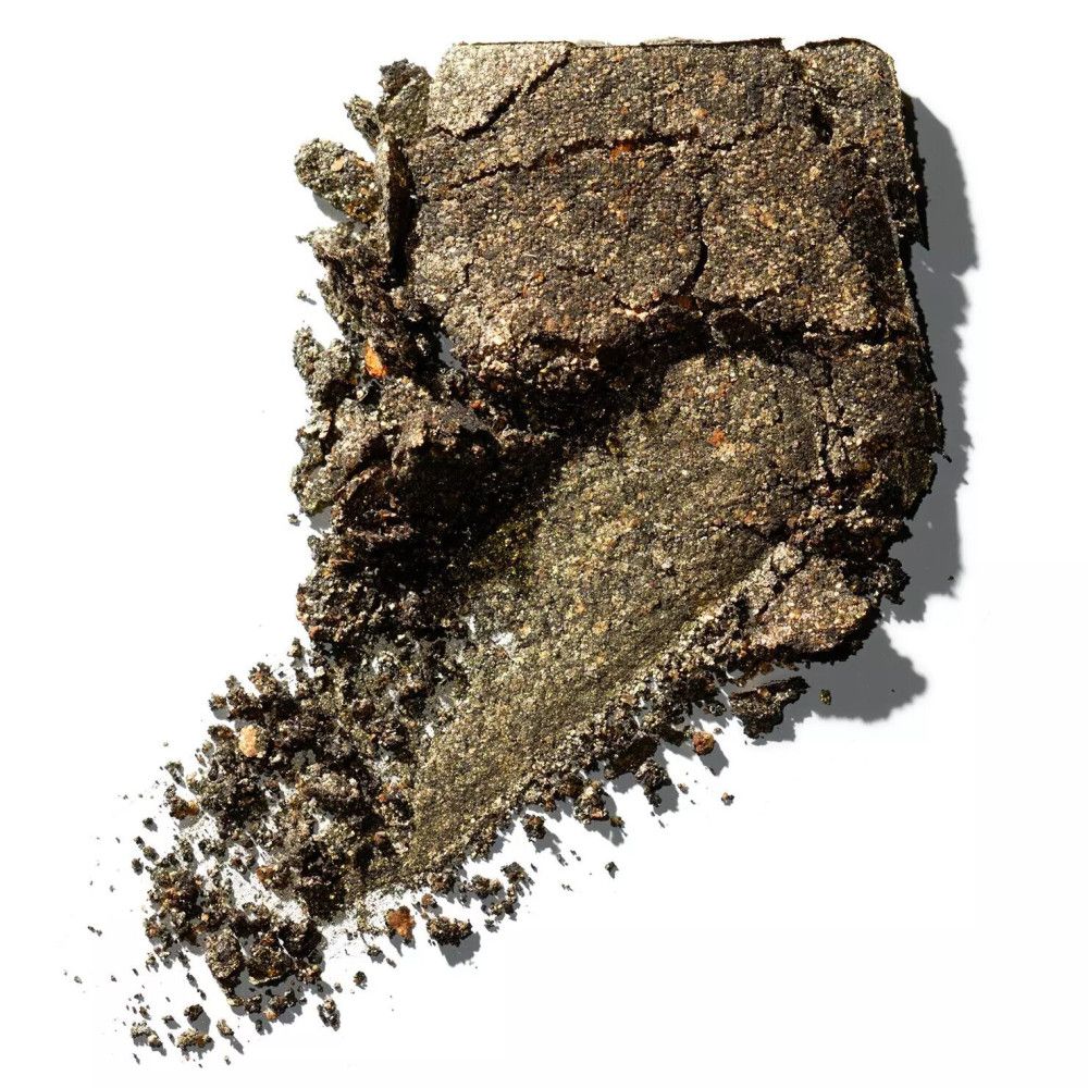 Fard à paupières cassé en or-vert. Texture avec particules visibles. Sur fond blanc.