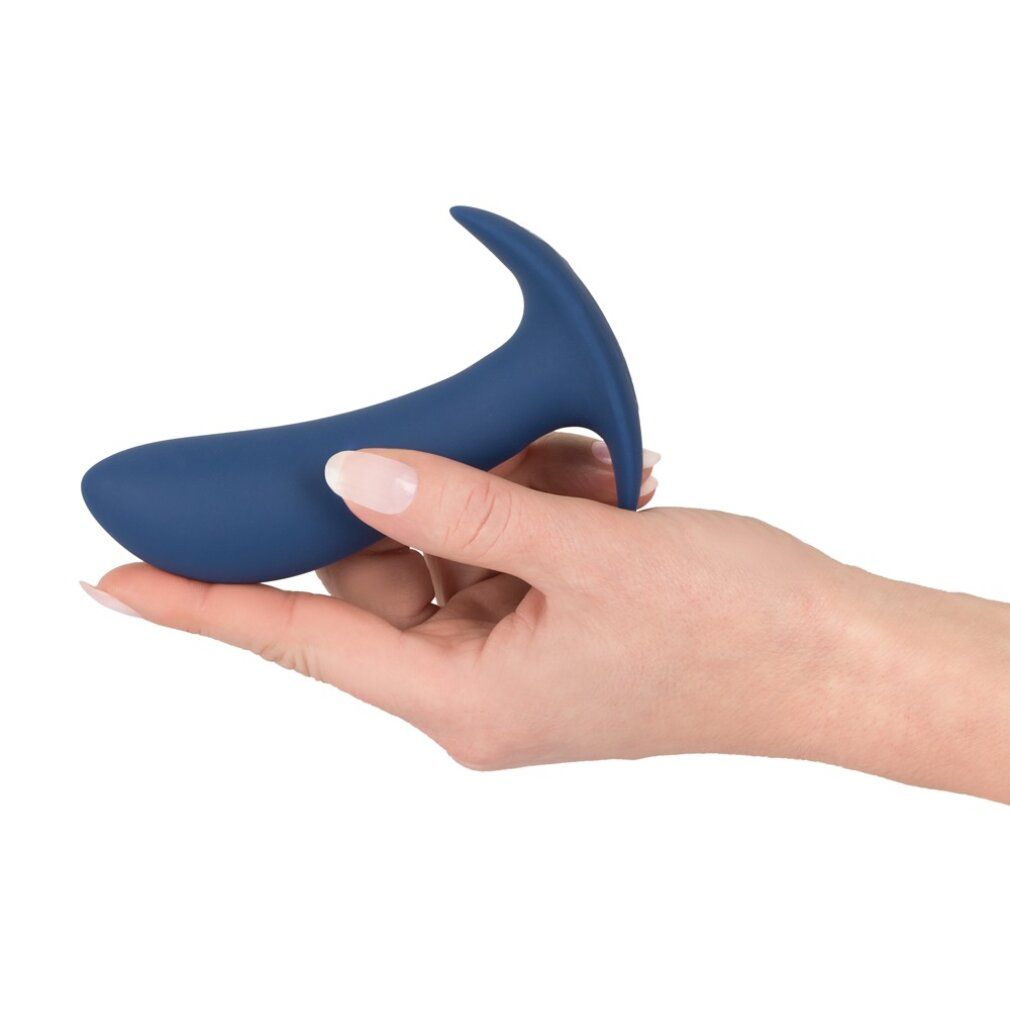 Hand die een donkerblauwe anale plug vasthoudt. Gebogen vorm, brede basis.