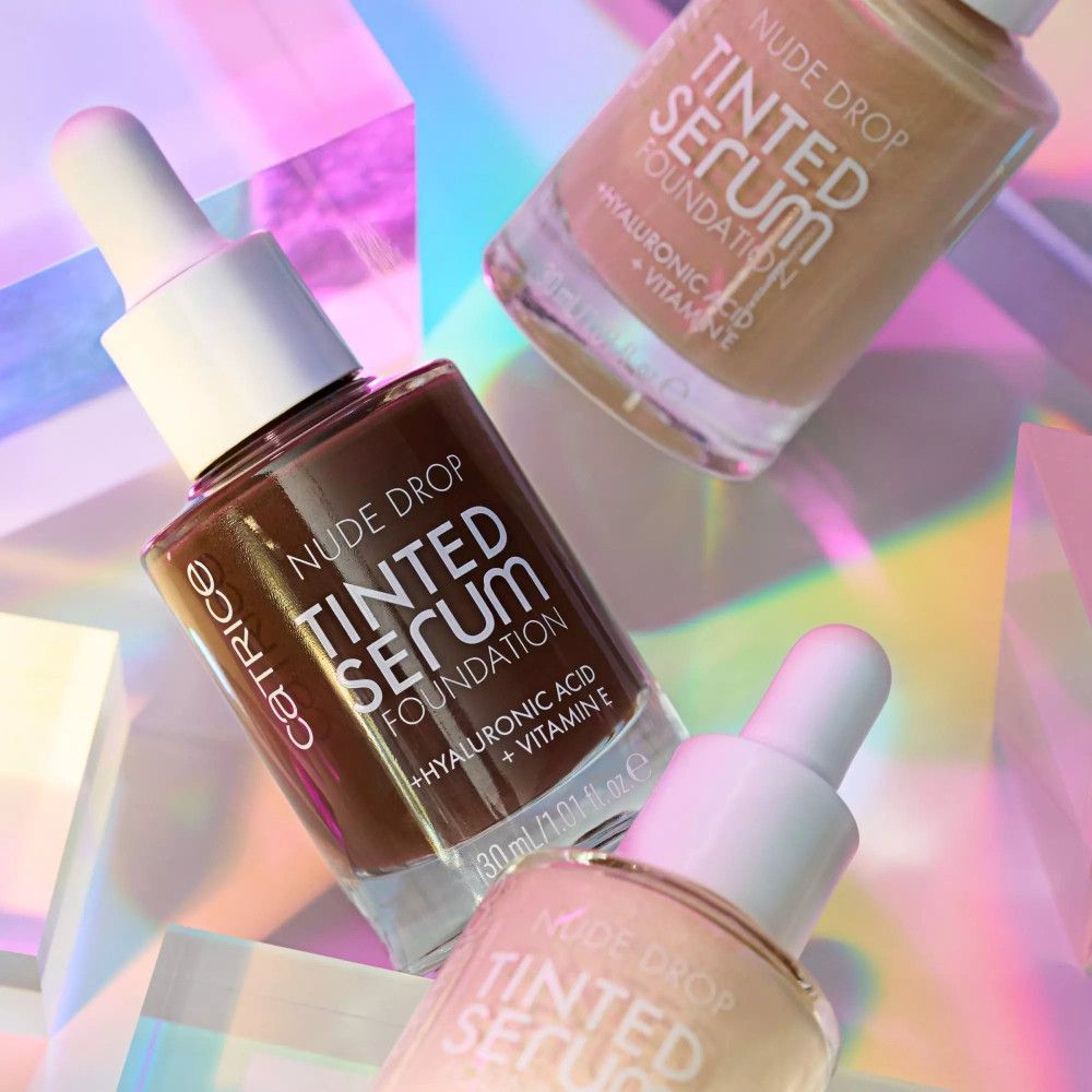 Trois flacons Catrice Nude Drop Sérum Teinté Foundation. Différentes teintes. Pipettes visibles.