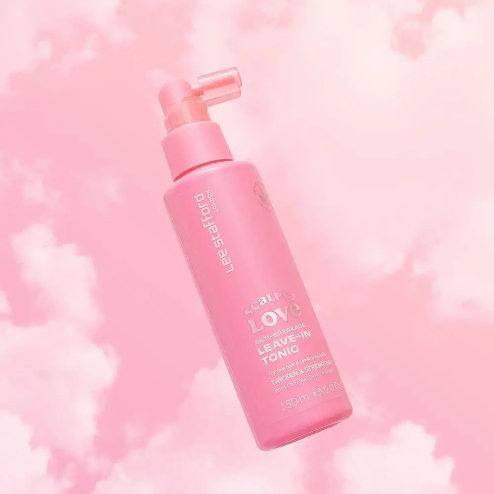 Roze fles met spraykop. Opschrift: Scalp Love Leave-in Tonic. Merk: Lee Stafford. Achtergrond: roze wolken.