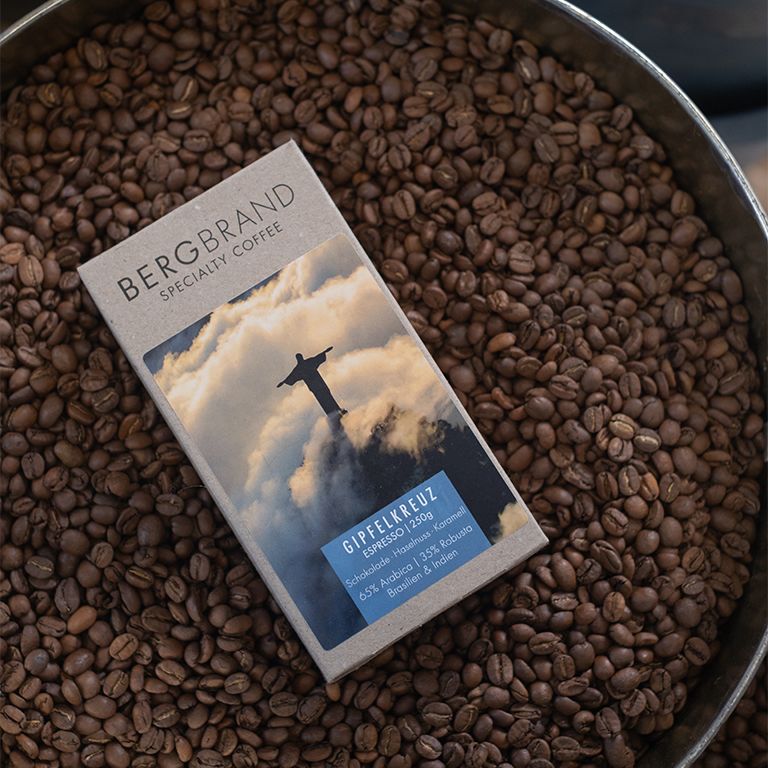 Paquet de café sur des grains. Impression : BERGBRAND Specialty Coffee, Gipfelkreuz Espresso Blend.
