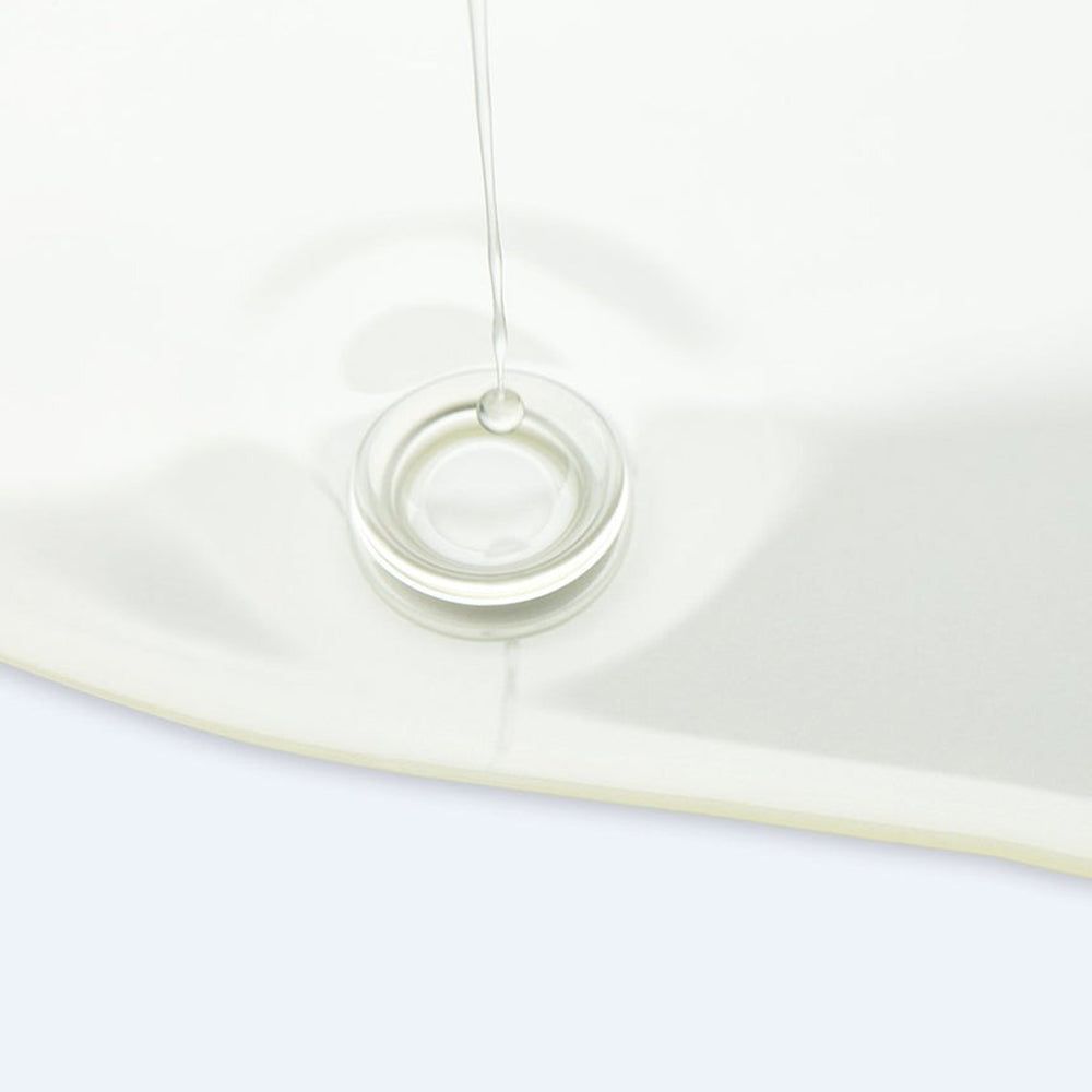 Helder transparante vloeistof die uit een transparante container druppelt. Op witte achtergrond.