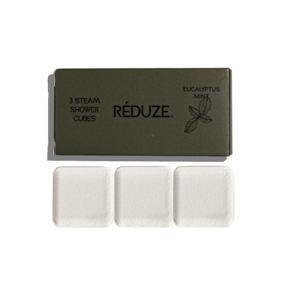 Drie witte, vierkante doucheblokjes naast een groene doos met tekst en logo.