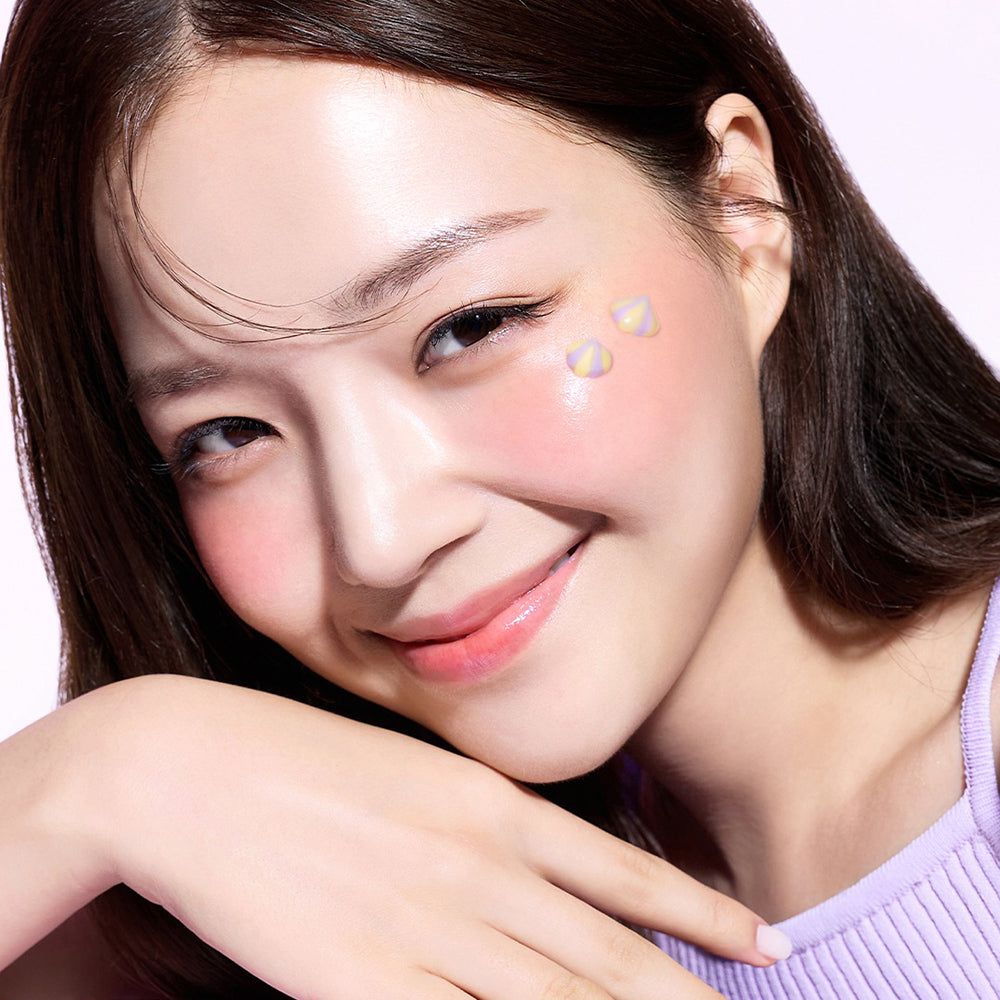 Femme souriante avec trois petites applications translucides en forme de cœur sur la joue.