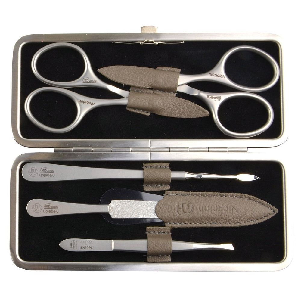 Open etui met manicuregereedschap. Schaar, pincet, nagelvijl en andere metalen instrumenten.