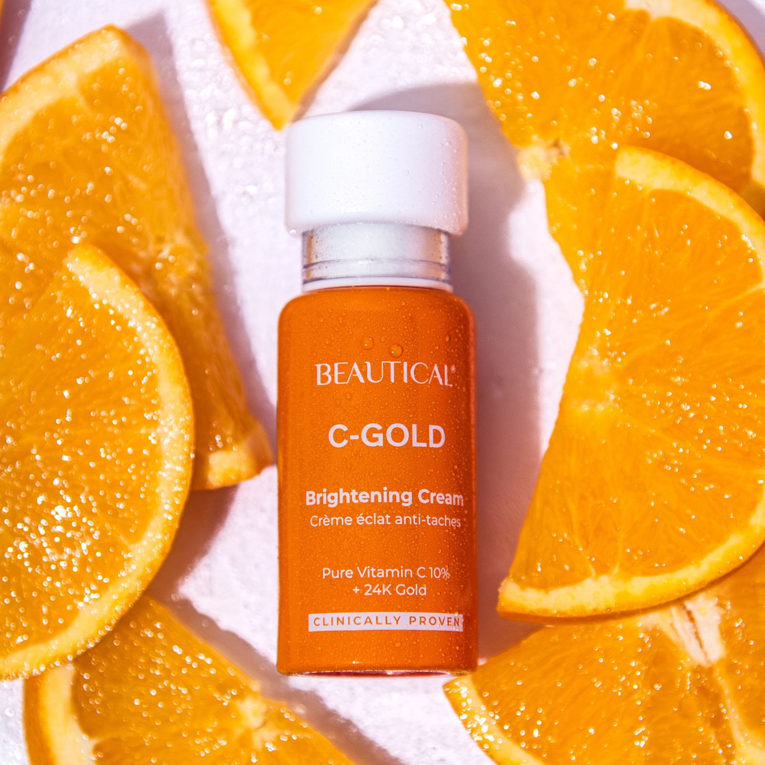 Productfles en sinaasappelschijven. Opschrift: BEAUTICAL C-GOLD Brightening Cream.